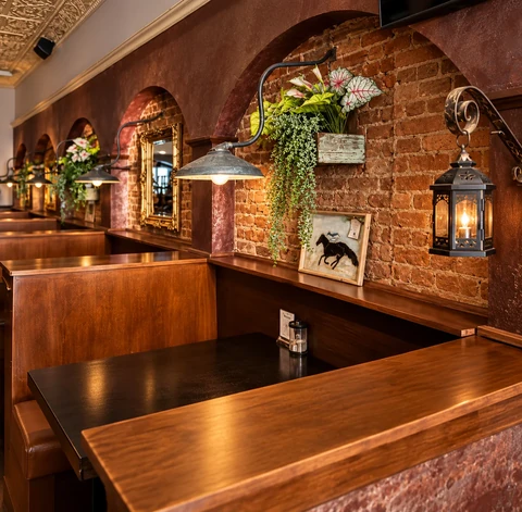 Wooden booths, exposed brick arches, and warm lantern lighting at 440 Barside.