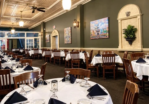 440 Main dining room with white tablecloths, warm lighting, and artwork.