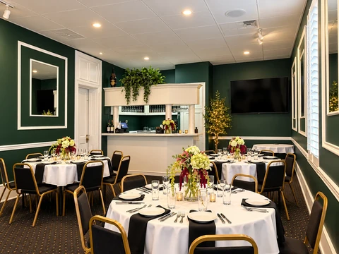 Private dining room at 440 Main with round tables, white tablecloths, and floral centerpieces.