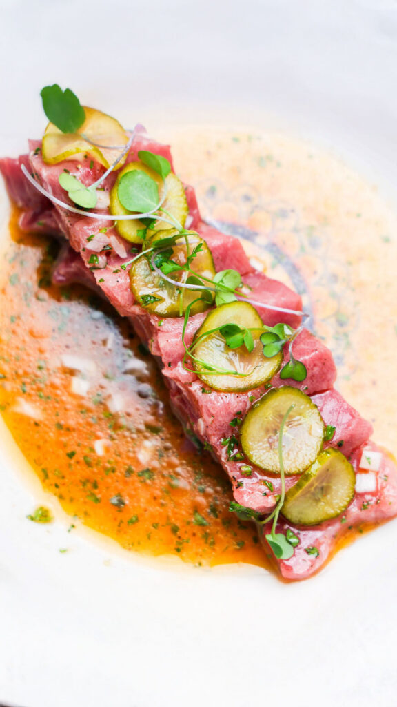 Sliced tuna served with vegetables and sauce at 440 Main.